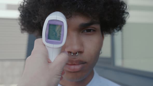 Hand Holding Infrared Thermometer to Measuring Temperature alt