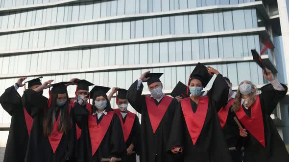 University Graduates Rejoice at the End of Their Studies Graduates in Medical Masks They Throw Hats alt
