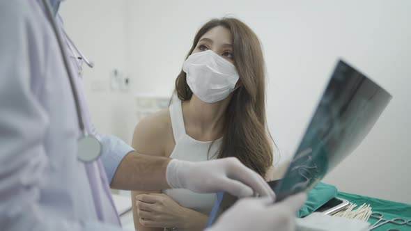 Male plastic doctor surgeon examining patients face for plastic surgery with facial x-ray film.