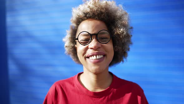 Cute African woman wearing red t-shirt looking around alt