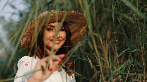 Woman touching tall grass in field