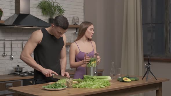 loving couple of athletes recording video food vlog about healthy cooking on phone camera alt