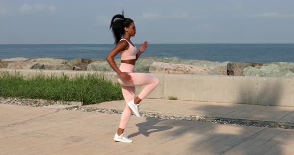 African american woman in sportswear seaside. Fitness girl. alt