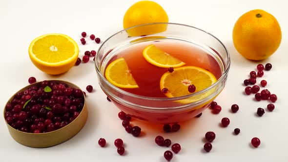 Non - alcoholic fruit punch with fresh cranberries and orange in a glass bowl.