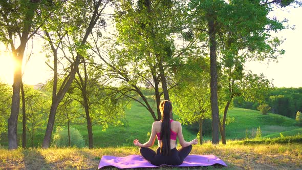 Back View of Woman Sitting on the Rug and Doing Zen Meditation.