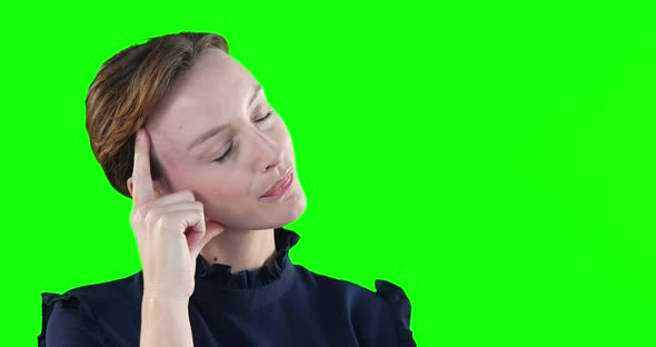 Caucasian woman thinking on green background