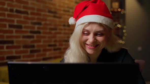 Woman working on laptop in christmas at home indoors. Attractive young adult caucasian girl alt