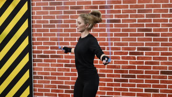 Young Beautiful Athlete Girl Jumps on a Rope