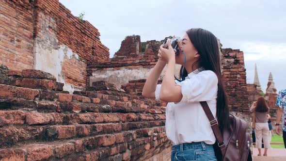 Asian woman using camera for take a picture while spending holiday trip at Ayutthaya, Thailand