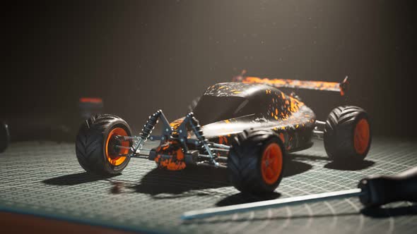 Assembled remote-controlled buggy car standing on a desk in the spotlight. 4KHD alt