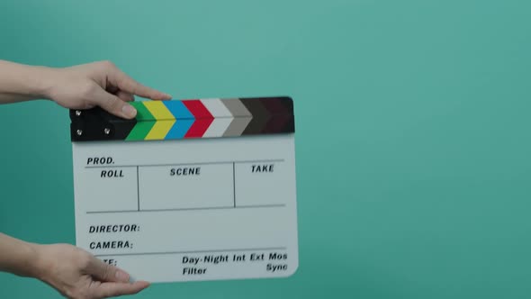 Clapperboard hitting. Movie film slate. close up hand clapping empty film slate on blue or green