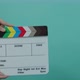 Clapperboard hitting. Movie film slate. close up hand clapping empty film slate on blue or green - VideoHive Item for Sale