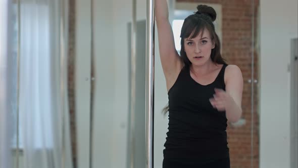 Young Pole Dancer Woman Wearing Balck Sports Wear Training and Looking at Camera alt