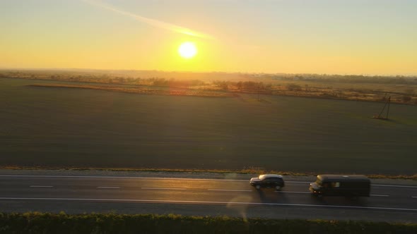 Aerial View of Intercity Road with Fast Driving Cars at Sunset alt