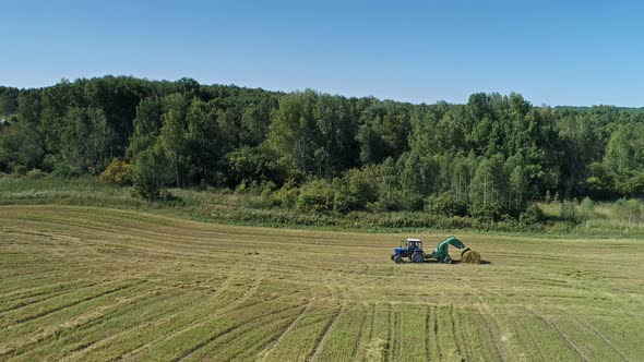 Tractor Baler Collecting Straw in the Field