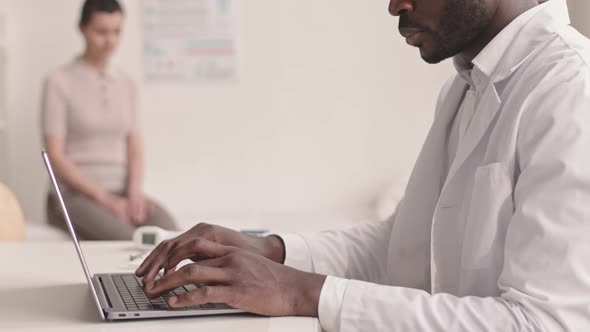 Doctor Using Laptop during Medical Appointment alt