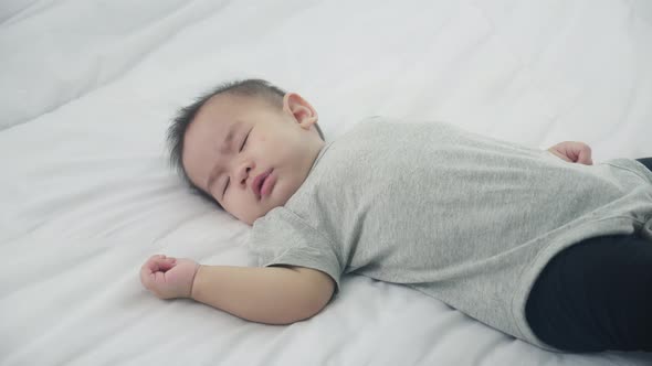 Portrait of asian little baby girl sleeping on bed in the bedroom at home, newborn napping with cozy alt