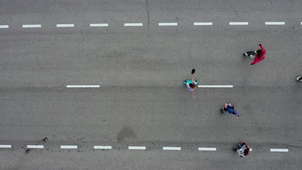 Aerial view of young women skatboarding on empty road