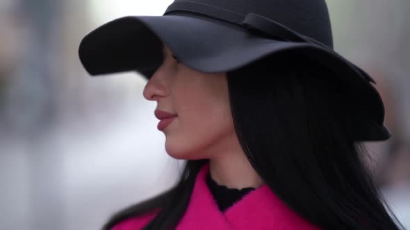 Portrait of a Brunette in a Black Hat and a Pink Coat alt