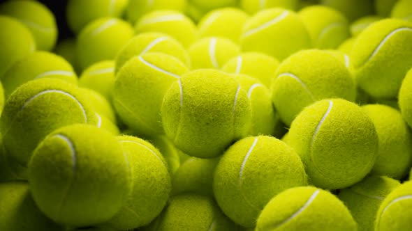 Seamless looping animation.Set of many tennis balls on the black background. alt