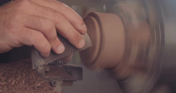 Artist creating a buddhist prayer wheel on a lathe alt