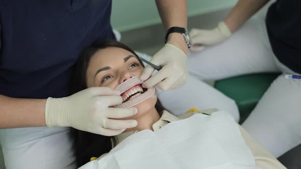 Professional Dentist Working With Gloves With Patients Teeth With an Open Mouth