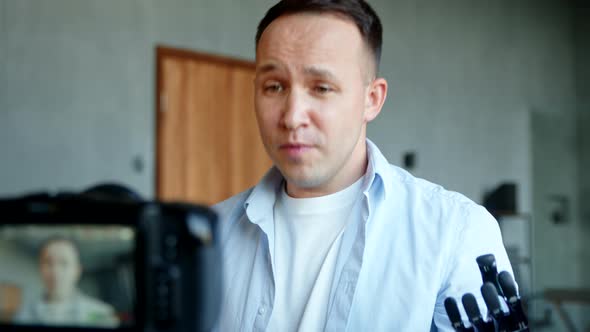 Experienced blogger man cyborg records stream gesticulating with artificial hand prothesis alt