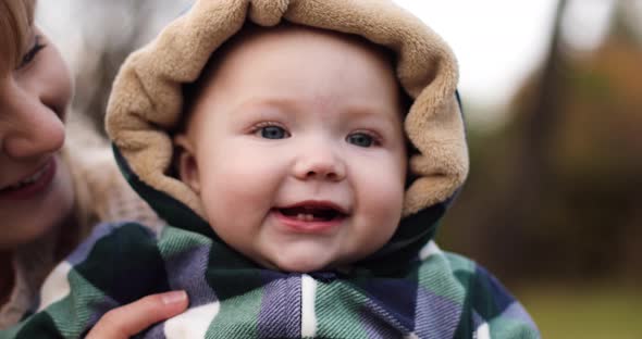 Close-up of Adorable Smiling Baby in Hood on Cold Day