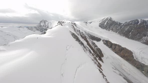 FPV Sports Drone Flying Over Mountain Ridge Snow Wind Overcast Cold Altitude Weather Environment alt