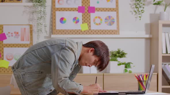 Young male studies and works distant on laptop from home make notes alt