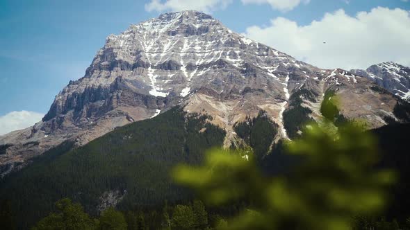 Beautiful clouds on top of a Rocky Mountain peak. alt