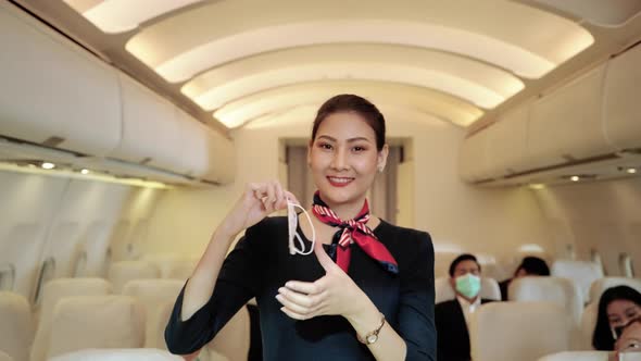 Flight attendant demonstrates wearing masks to prevent COVID-19 infection.