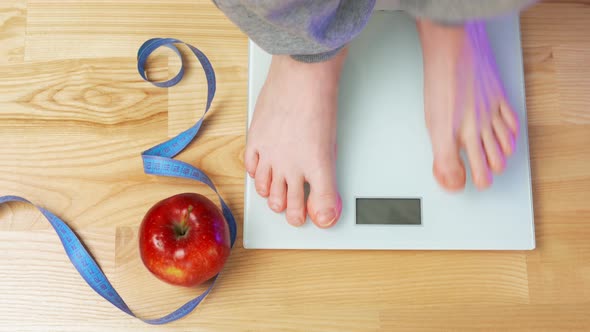 A Woman Gets on the Scales and Sees Her Weight of 63 Kg