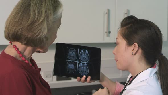 CU Female doctor on tablet discussing with senior patient in hospital / London, United Kingdom