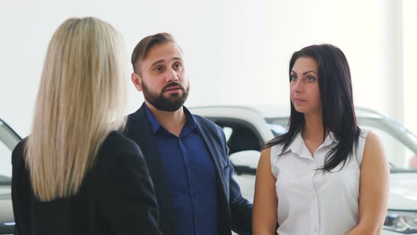 Young Family Buys a New Car. The Manager Explains the Characteristics of New Car Buyers