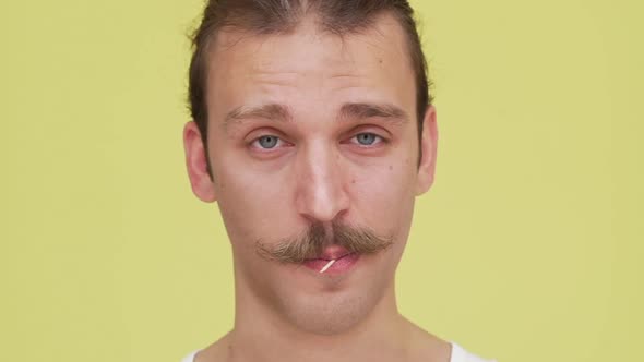 Slow Motion Confident Young Man Looking at Camera with Toothpick in His Mouth Closeup alt