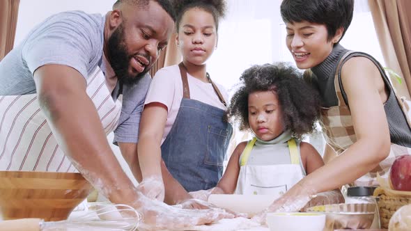African American kids and family preparing flour to make bread in kitchen at home.