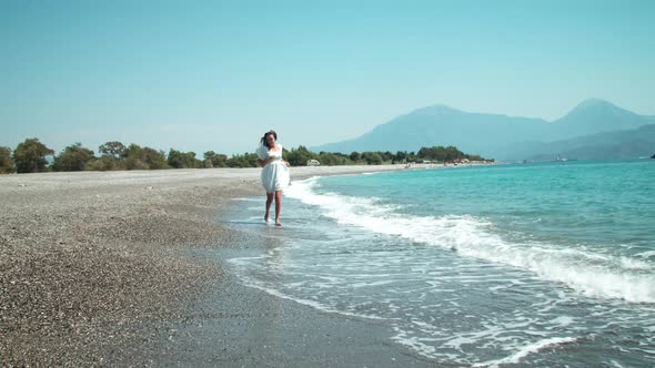 Happy Young Woman Dancing Near Waving Sea