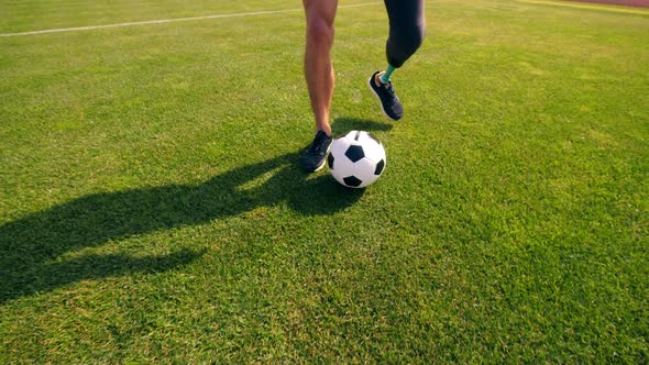 A Football Is Being Dribbled By a Man with a Prosthetic Leg alt