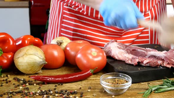 Chef Beats Fresh Raw Slices Pork Meat with Kitchen Hammer Before Cooking on Cutting Board