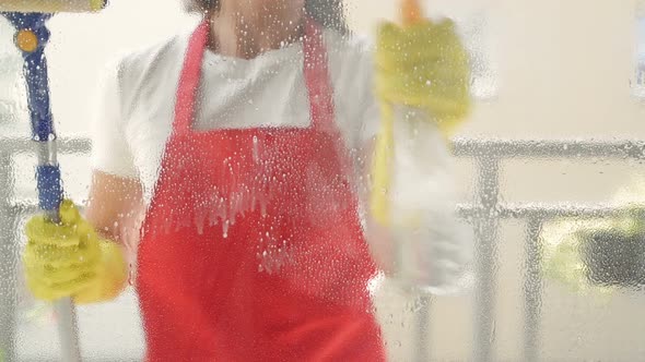 Cleaning Service Worker or Housewife Washes the Windows Using Detergent and Window Wiper alt