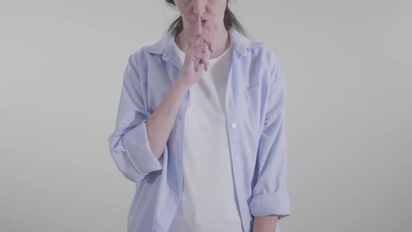 Unrecognizable Young Caucasian Woman Putting Finger To Lips Making Silence Gesture. Adult Lady alt