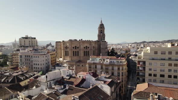Flyover city rooftops towards Malaga Cathedral, slowly ascending view, Spanish cities