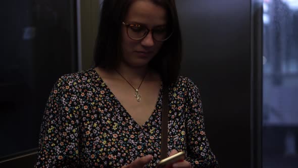 Close Shot of Young Attractive Ukraine Female in Glasses Sitting on Moving City Metro Train alt