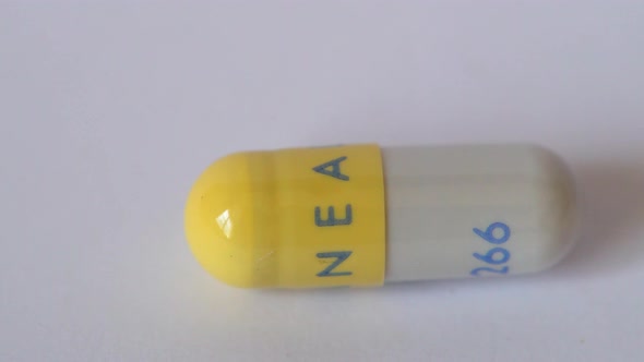 Close Up Pan of a White and Yellow Antidepressant Capsule Drug alt