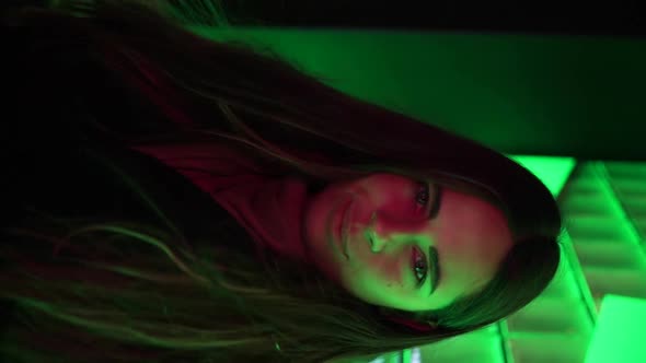Portrait of the Beautiful Blonde Young Woman Standing Among Neon Lights and Smiling Cheerfully To