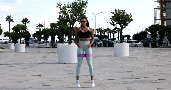 Young fit sporty black African woman in top and leggings does leaning forward exercise.