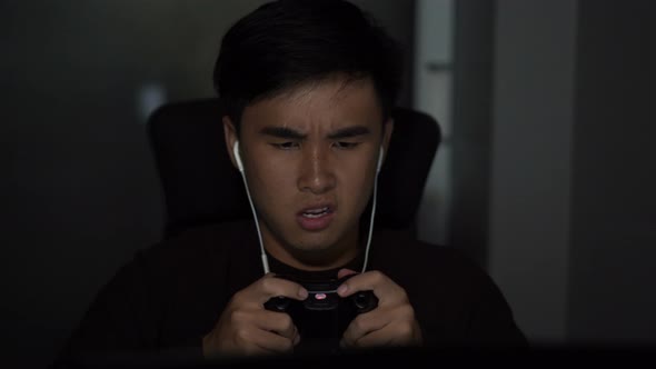 Stressed depressed young man using joystick to playing games alt