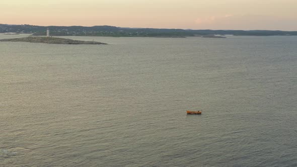 Yellow Boat Sailing At The Seascape With A Distant View Of Lille Torungen Lighthouse In Agder County alt