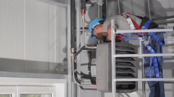 Hvac Professional Inspecting Insulated Pipes Connected alt